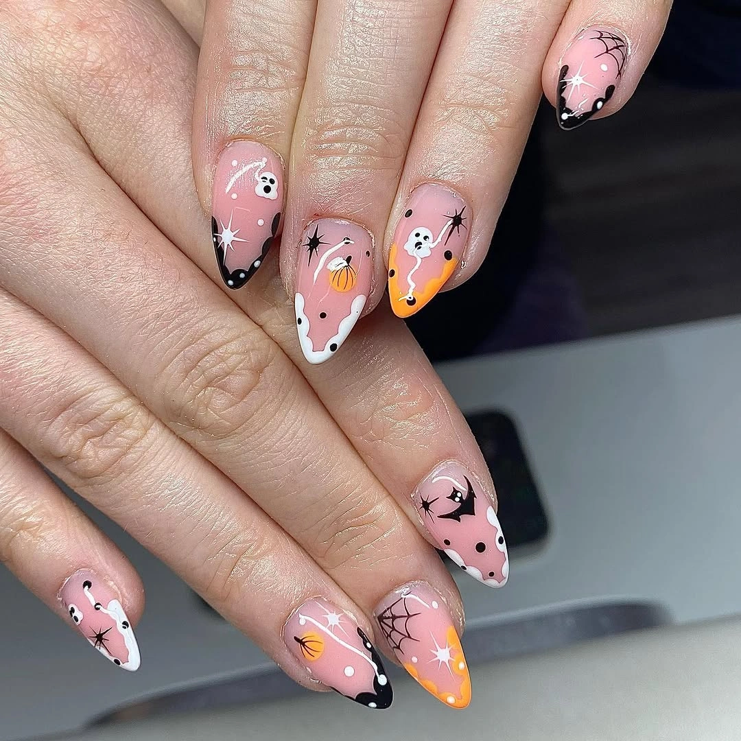 Pale pink almond nails with graphic tips pumpkins and stars