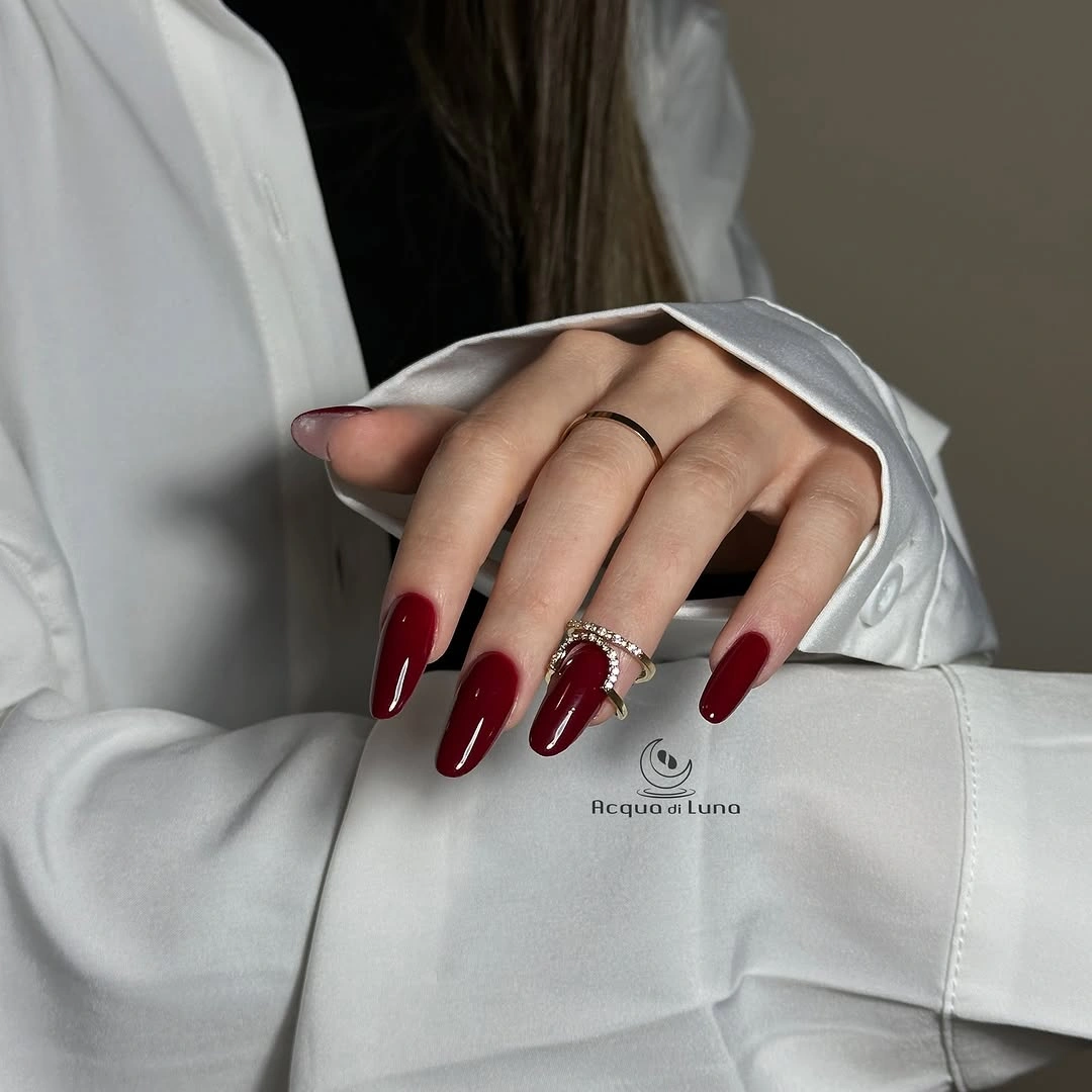 Long glossy almond nails in deep red-wine maroon color