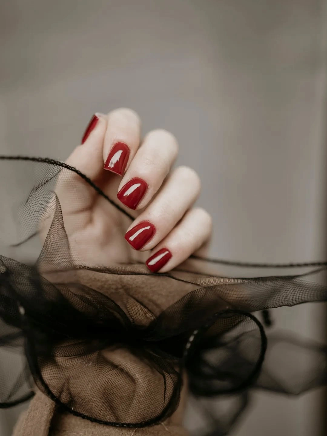 Short warm red squoval nails with glossy clean solid color