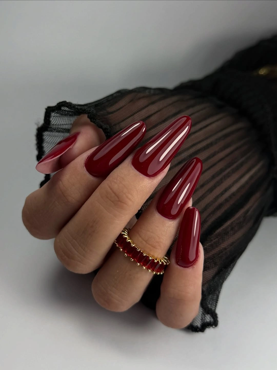 Long almond nails in rich deep red with smooth glossy reflections