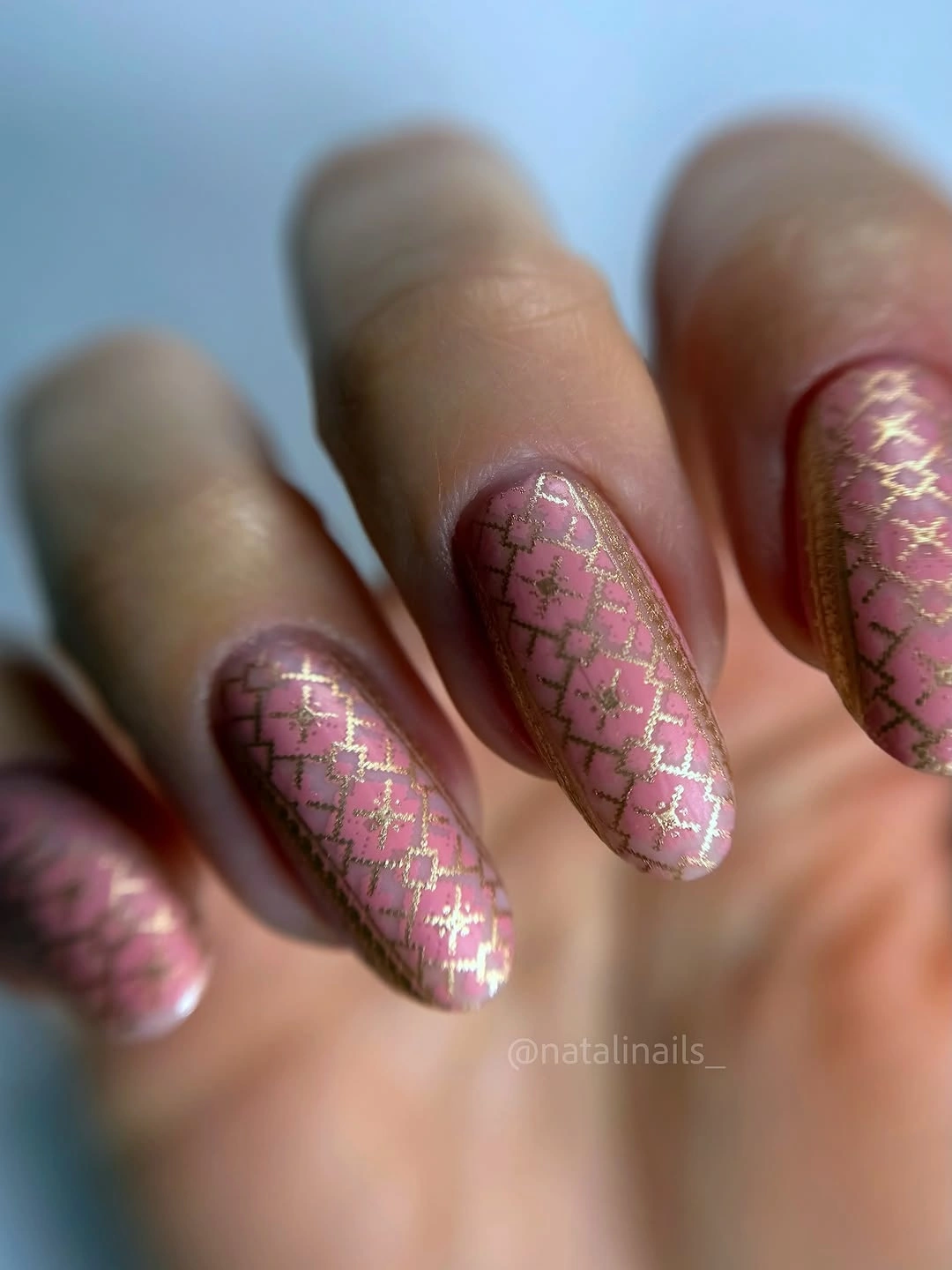Long pink almond nails decorated with fine gold crisscross lattice lines