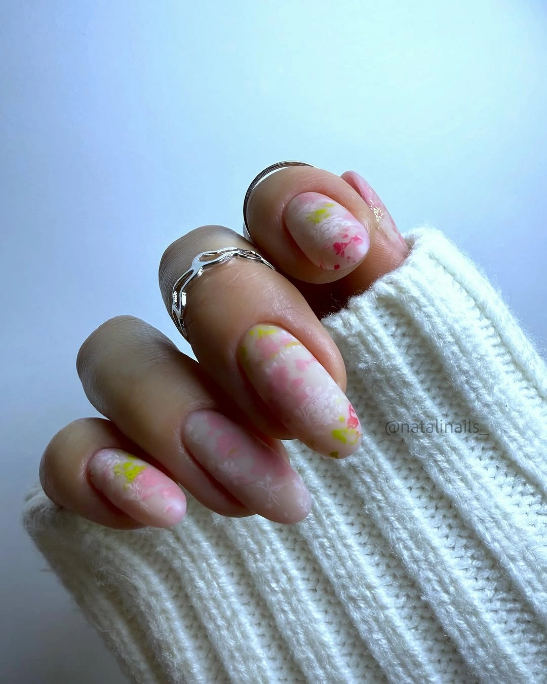 Milky pink almond nails with soft blurred pink and yellow-green accents