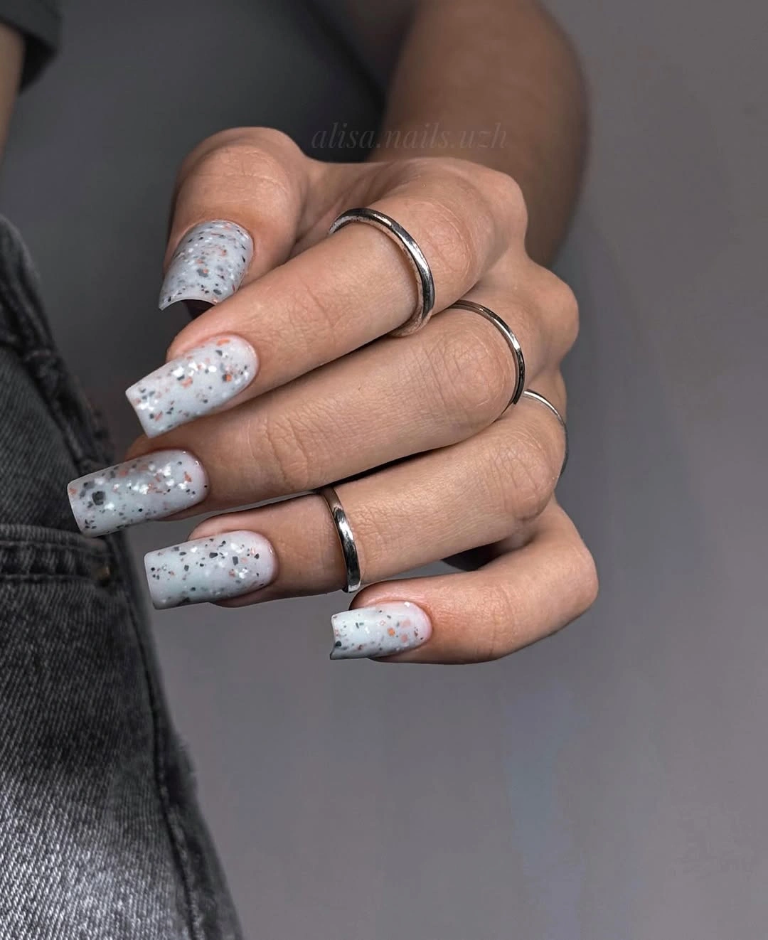 Long milky white coffin nails with tiny scattered red and dark flecks