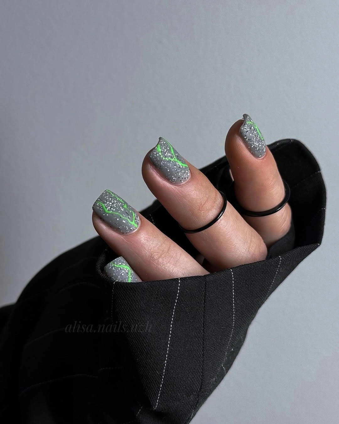 Silver glitter square nails traced with slim bright neon green outline details