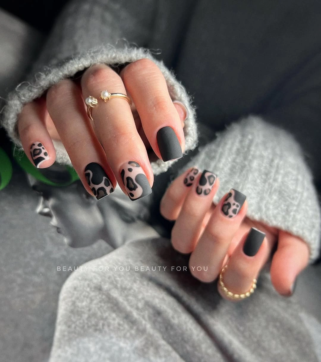 Matte taupe square nails with irregular black cow-print accents