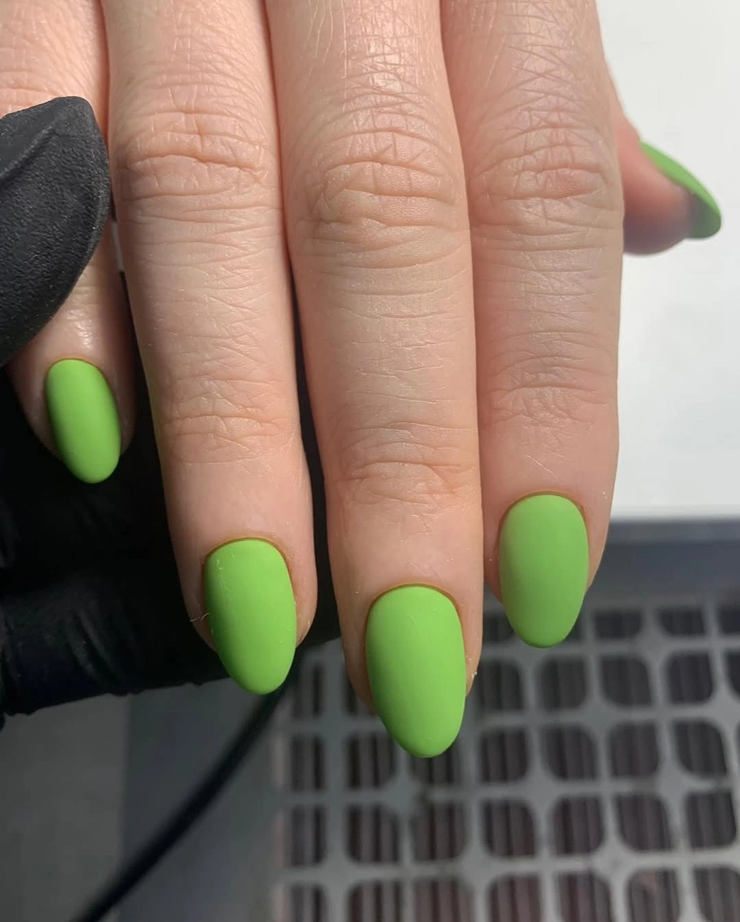 Short rounded oval nails in saturated grass green matte polish