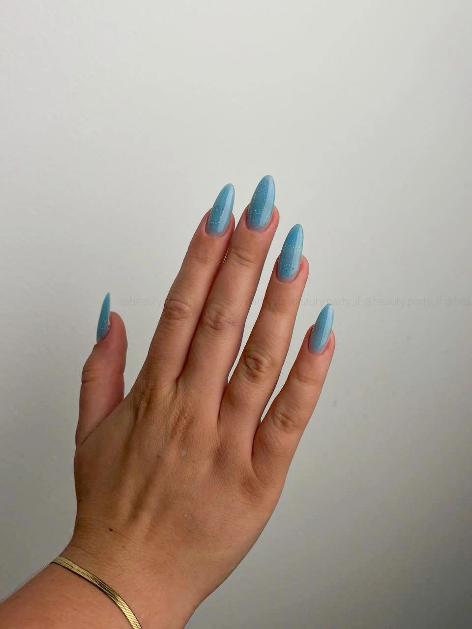 Long pointed pale nails with vivid blue tips