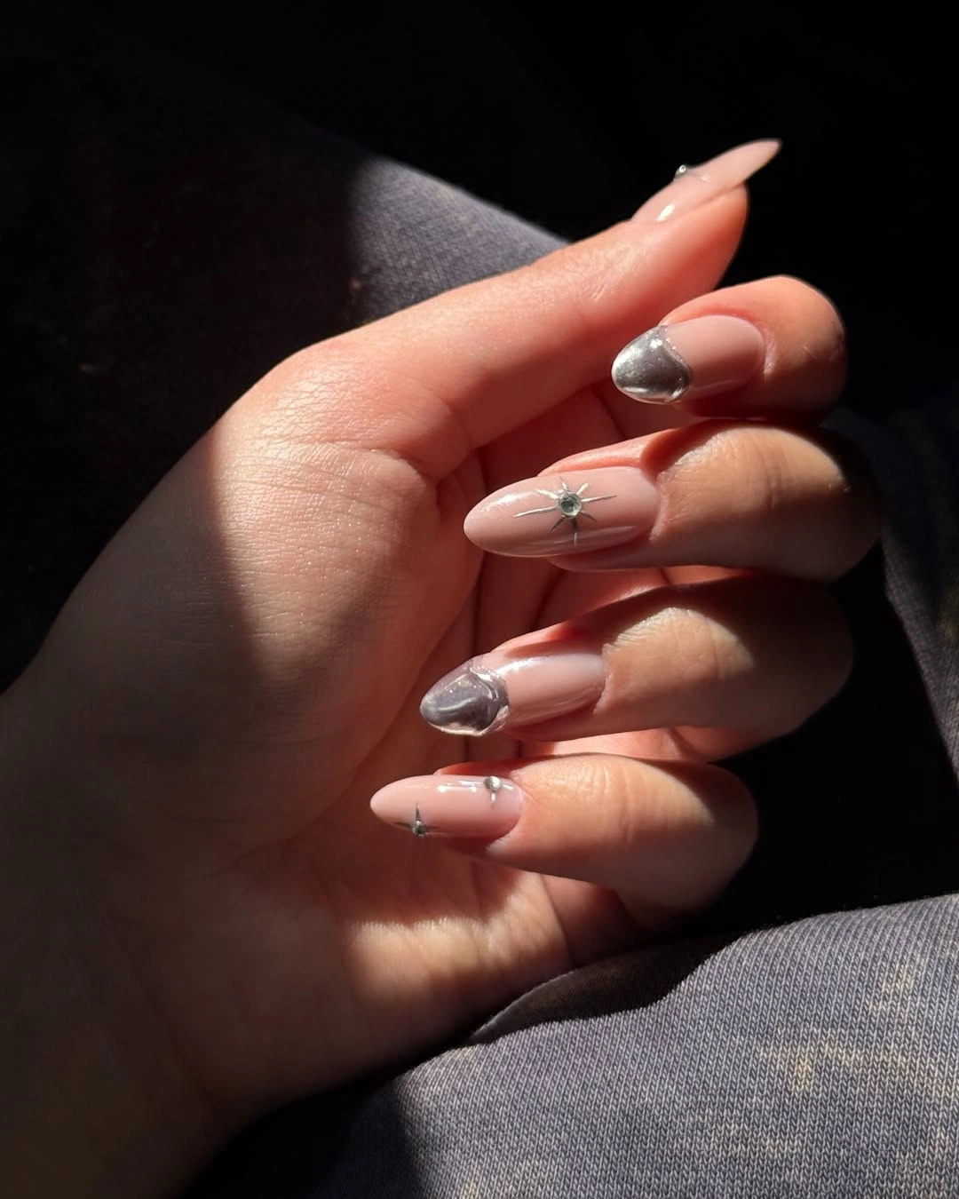 Long pale pink almond nails with silver accents