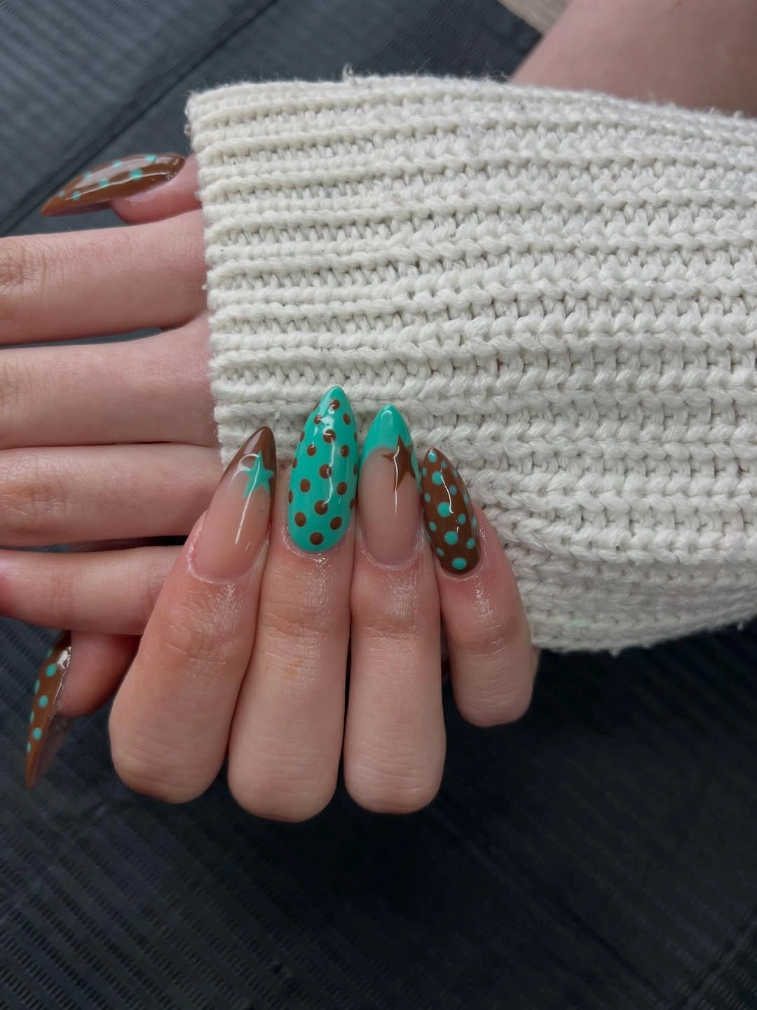 Long nude almond nails with teal brown dotted details and small star outlines