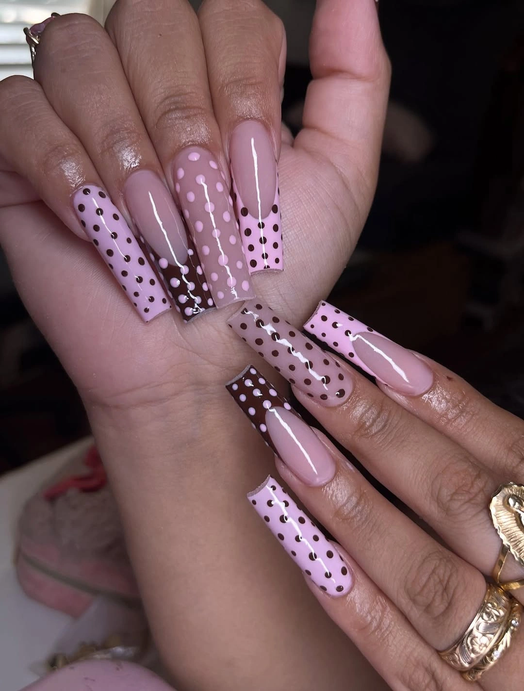 Long square nails with pale pink brown panels and contrasting polka dots