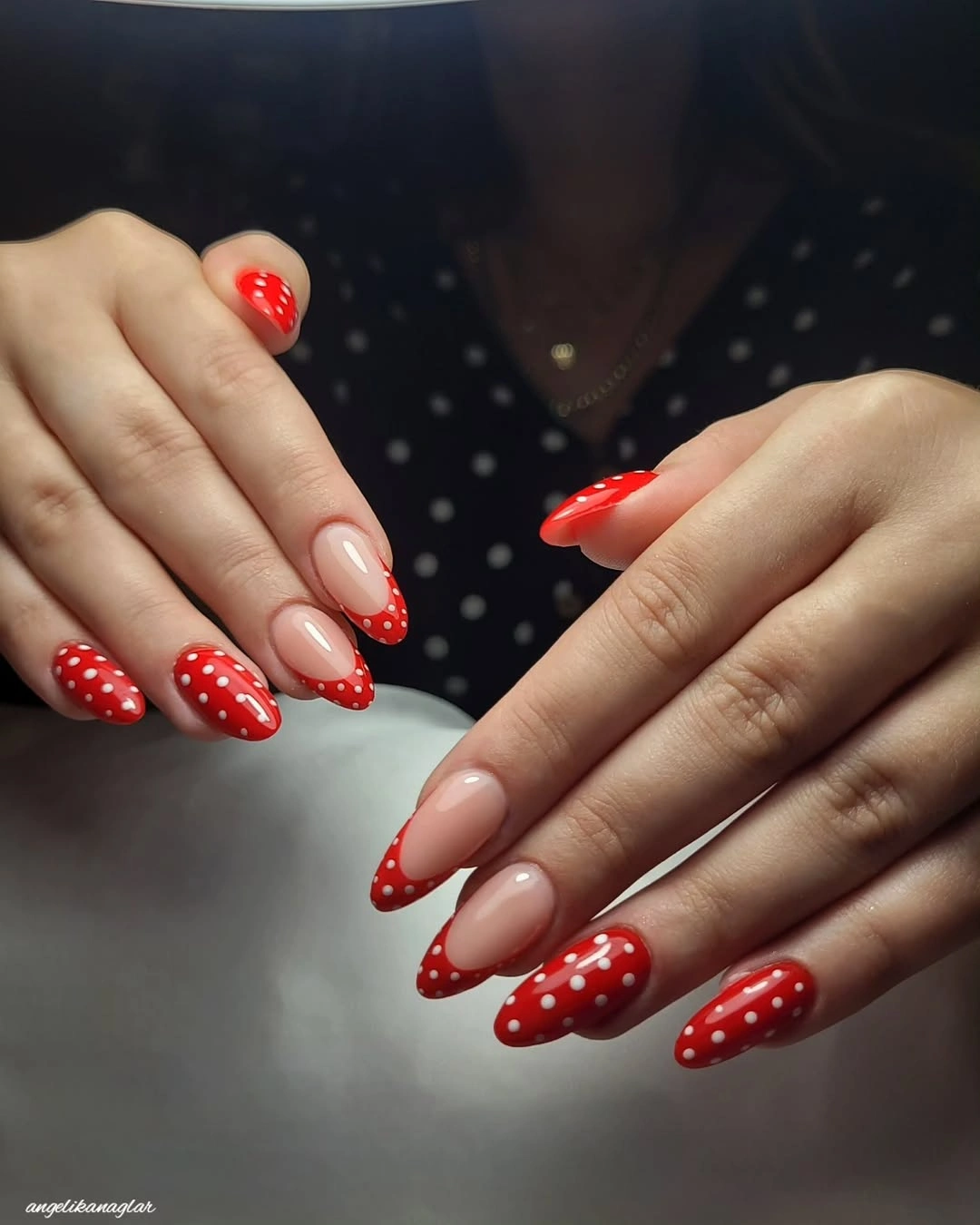 Long nude almond nails with vivid red French tips and white dotted details
