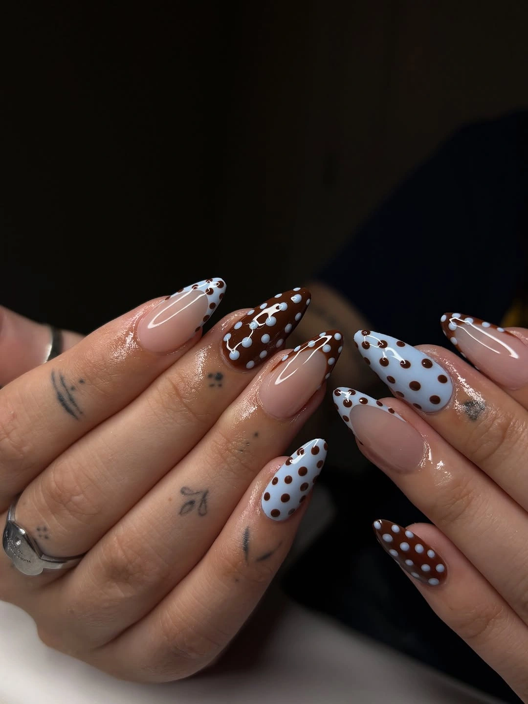 Long nude almond nails with brown white and dotted patterned sections