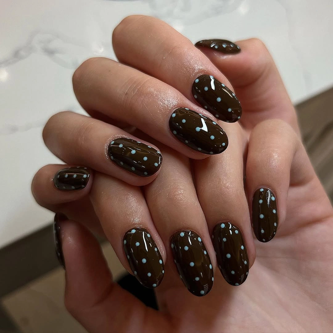Short oval dark brown nails with small cool blue polka dots