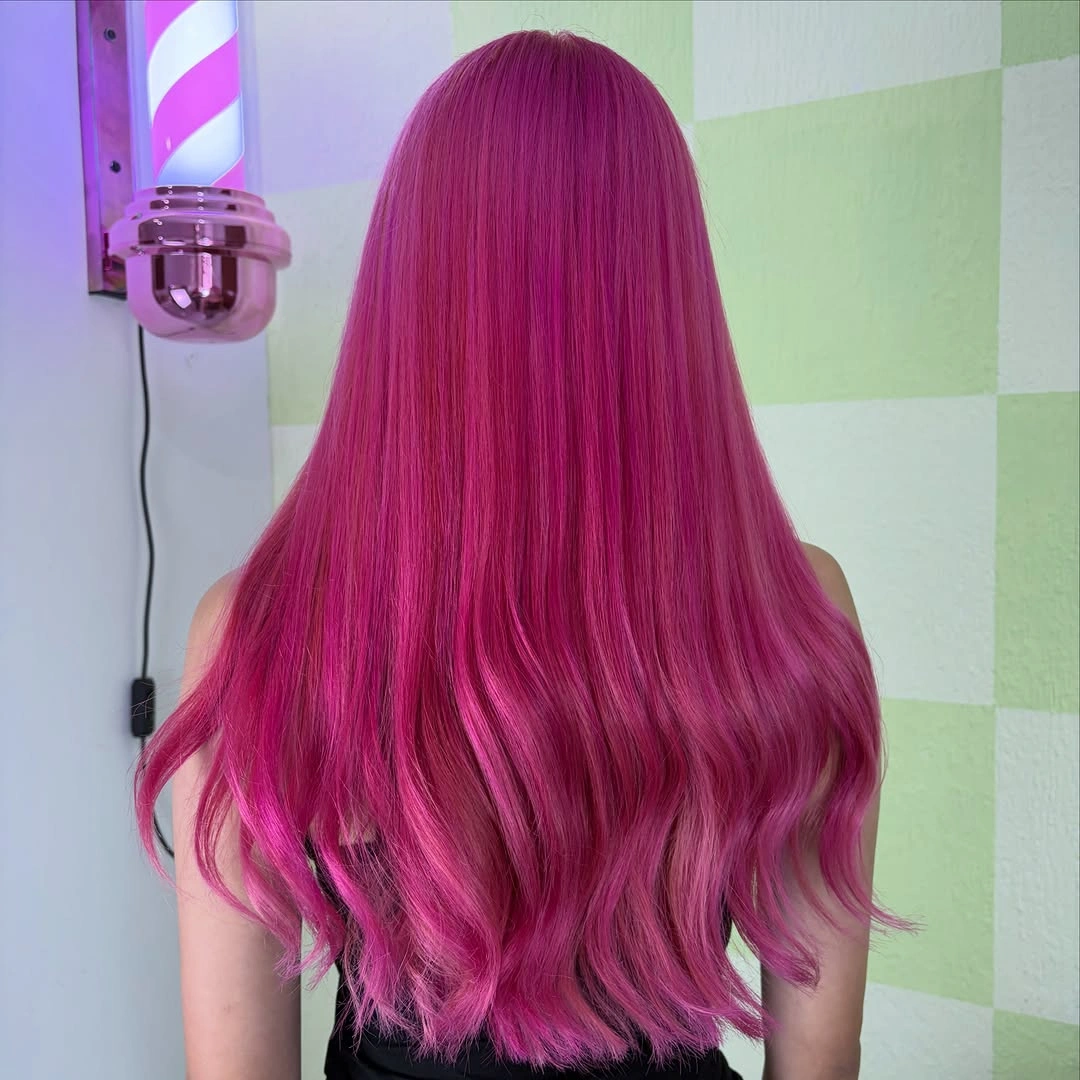 Long vivid magenta hair with soft waves through the ends