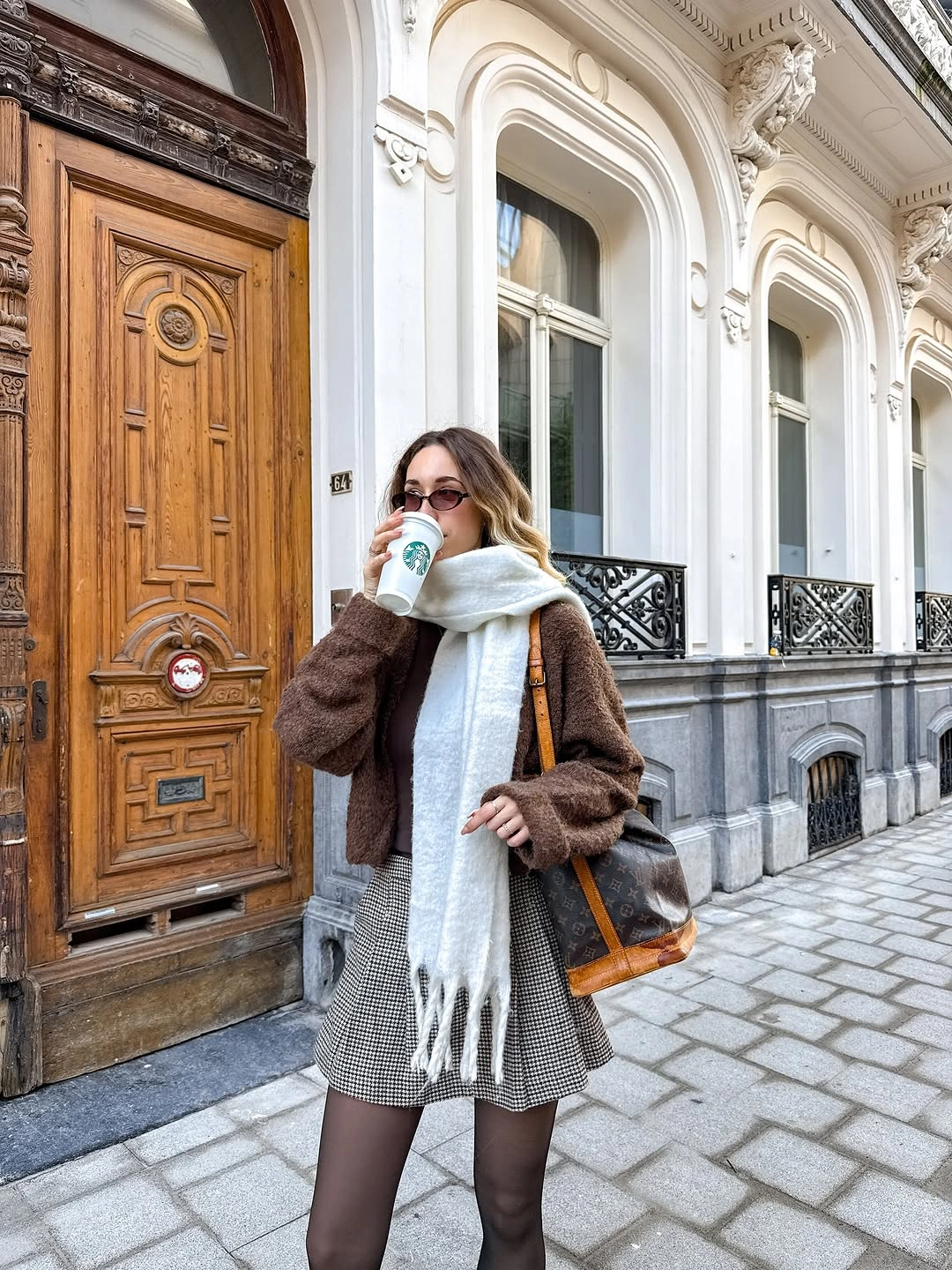 Brown textured jacket with checked mini skirt and tights