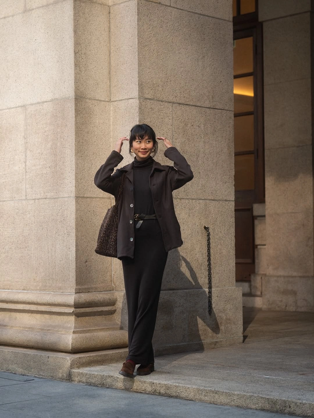 All-black tailored jacket and trousers with brown shoes