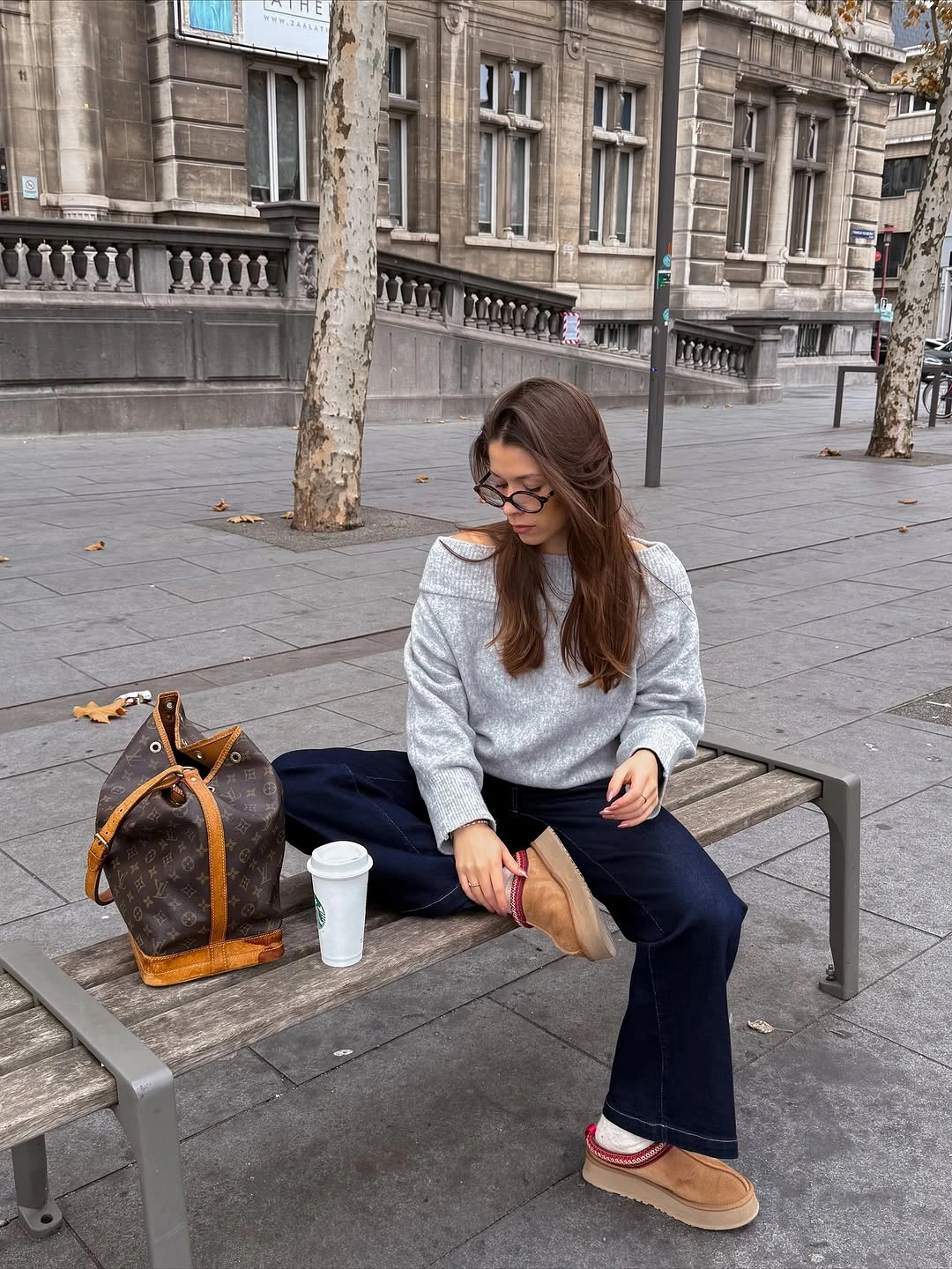 Taupe overshirt with striped black pants and dark tote