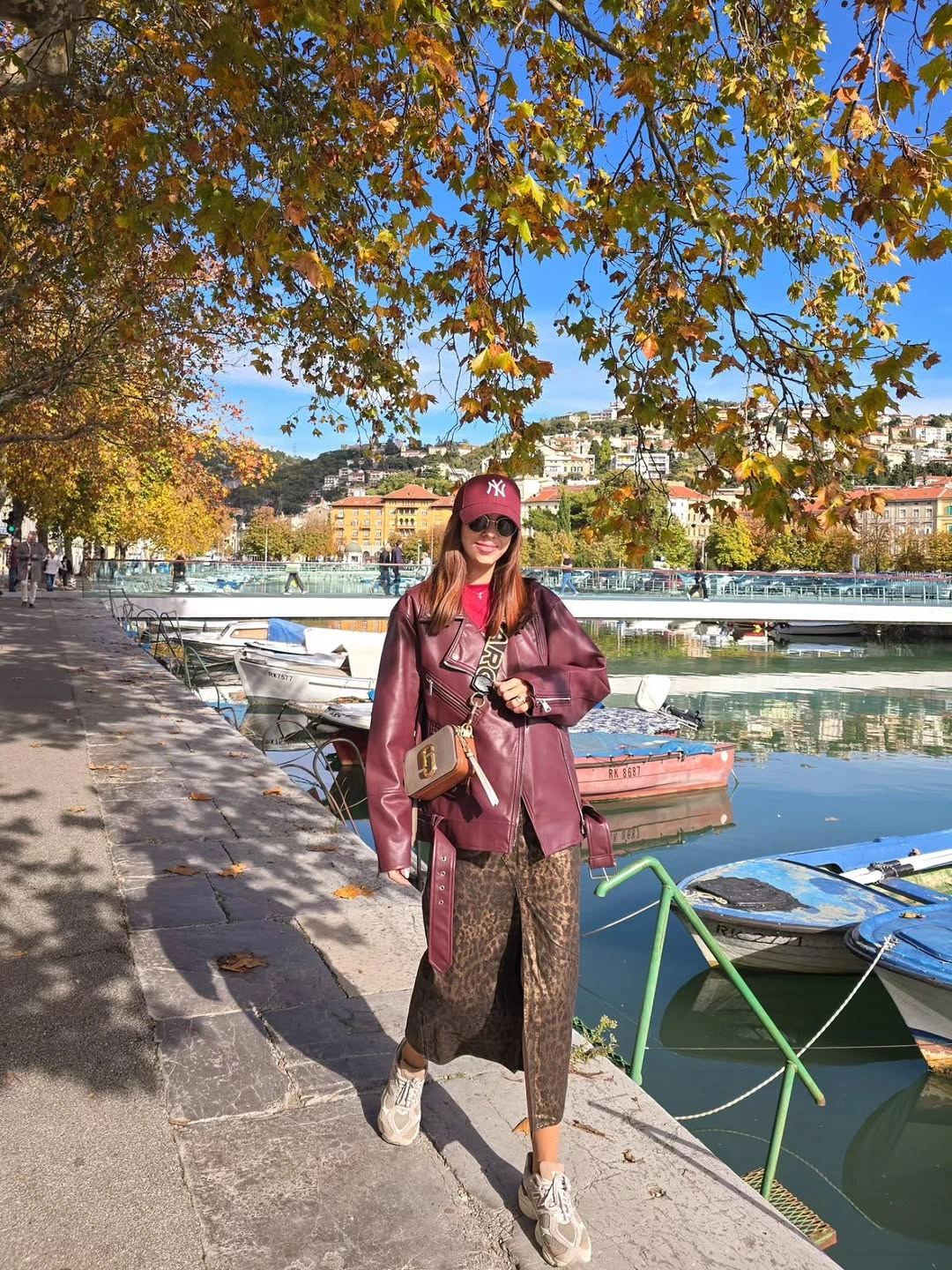 Burgundy jacket with patterned midi skirt and white sneakers