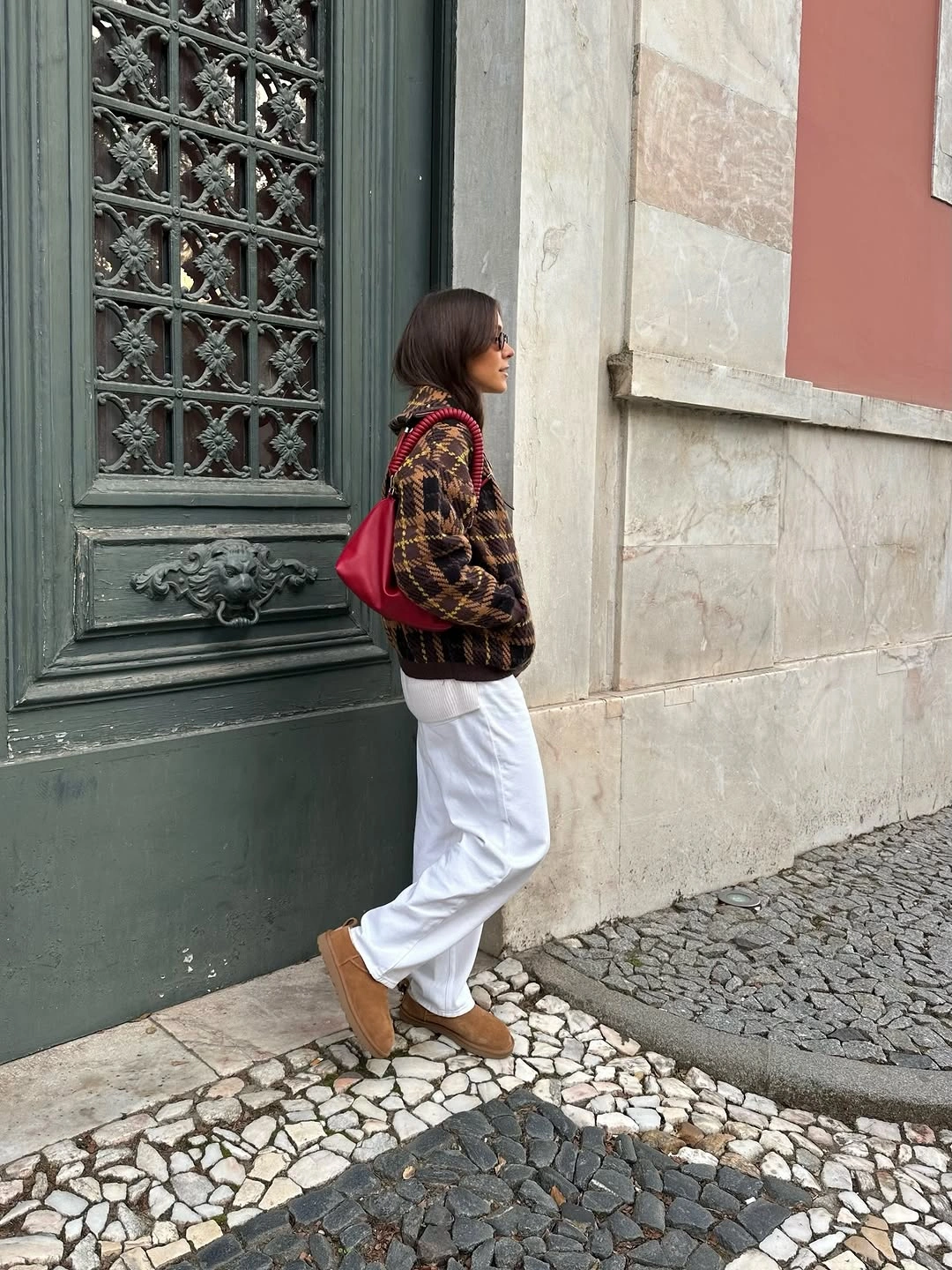 Checked cardigan over white top and trousers with red bag