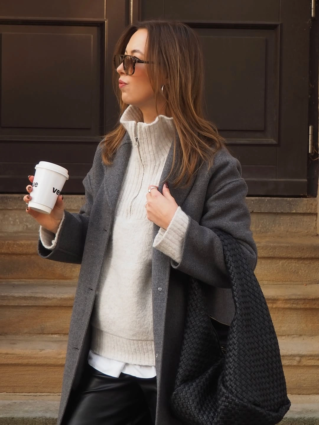 Long gray coat with chunky cream turtleneck and dark tote