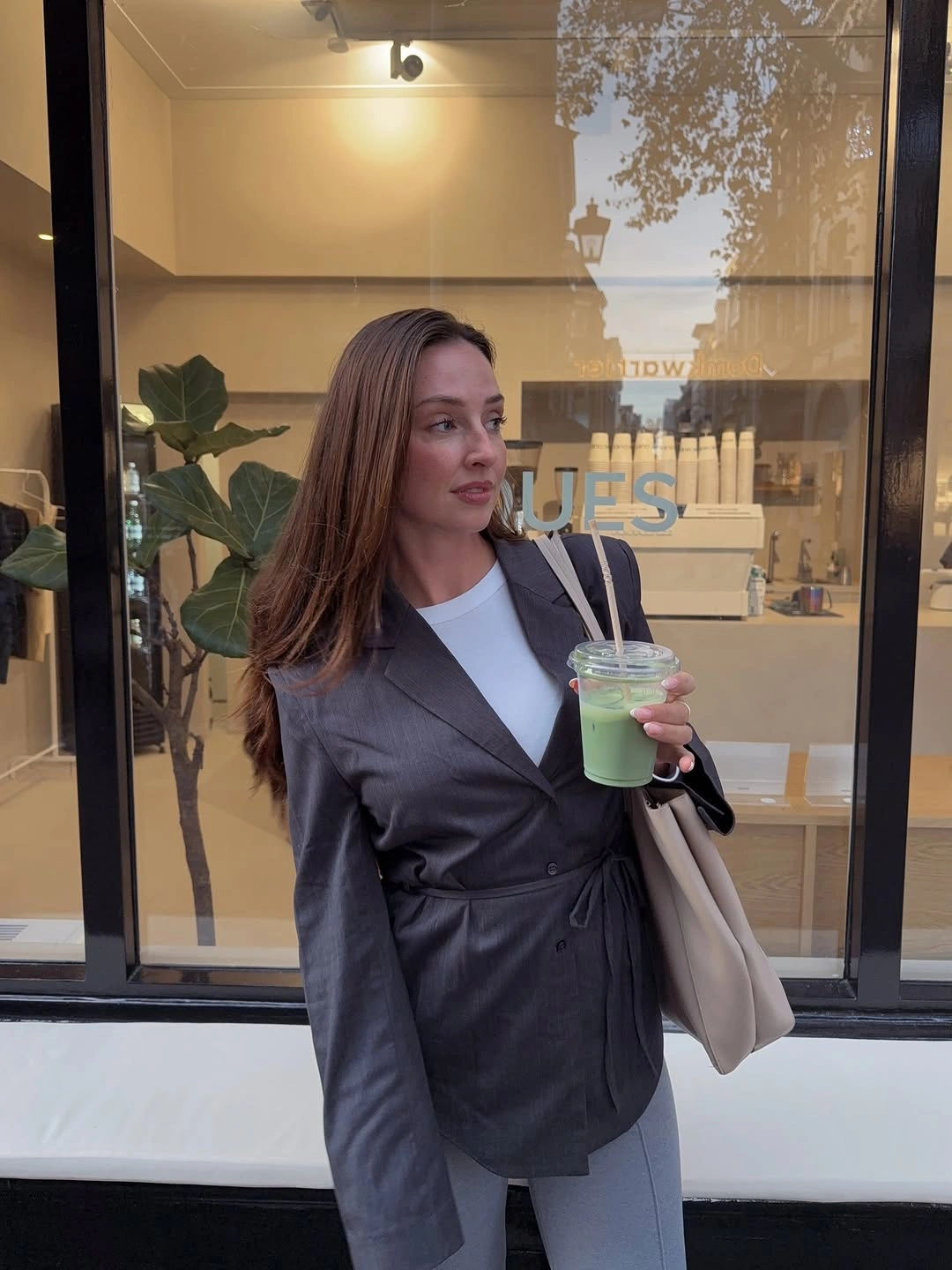 Gray wrap blazer with white top, pale trousers, and tote