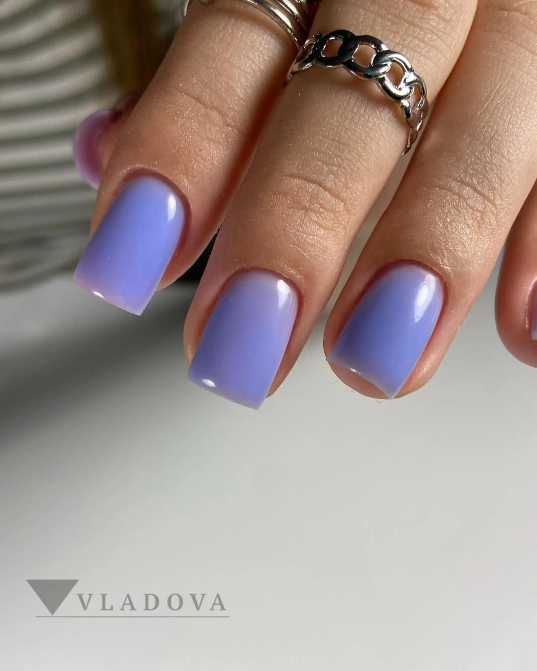 Short glossy lavender square nails in a soft pastel shade
