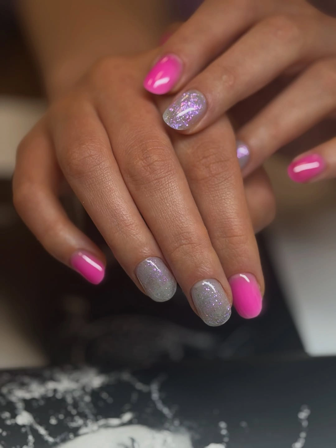 Short pink nails paired with soft silver glitter accent nails
