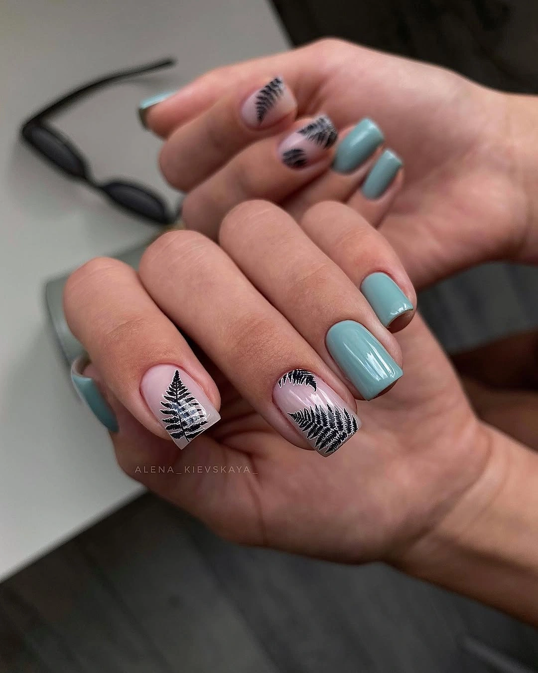 Short teal square nails with white botanical line accents