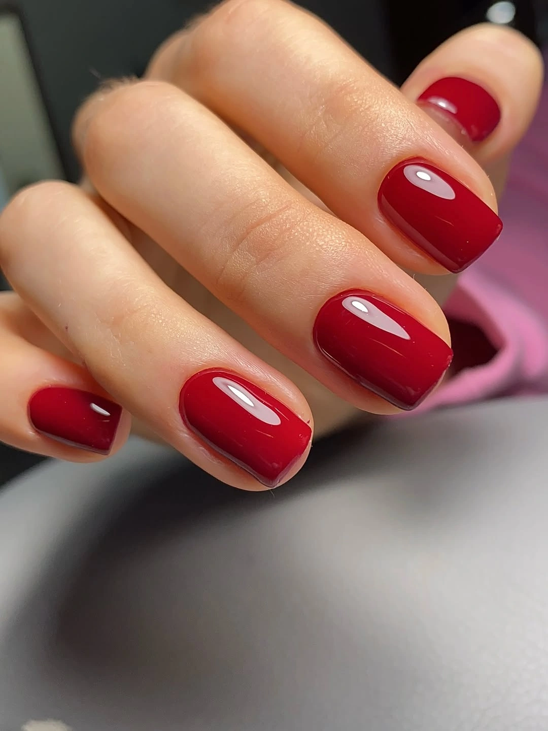 Short glossy cherry red square nails in a solid color