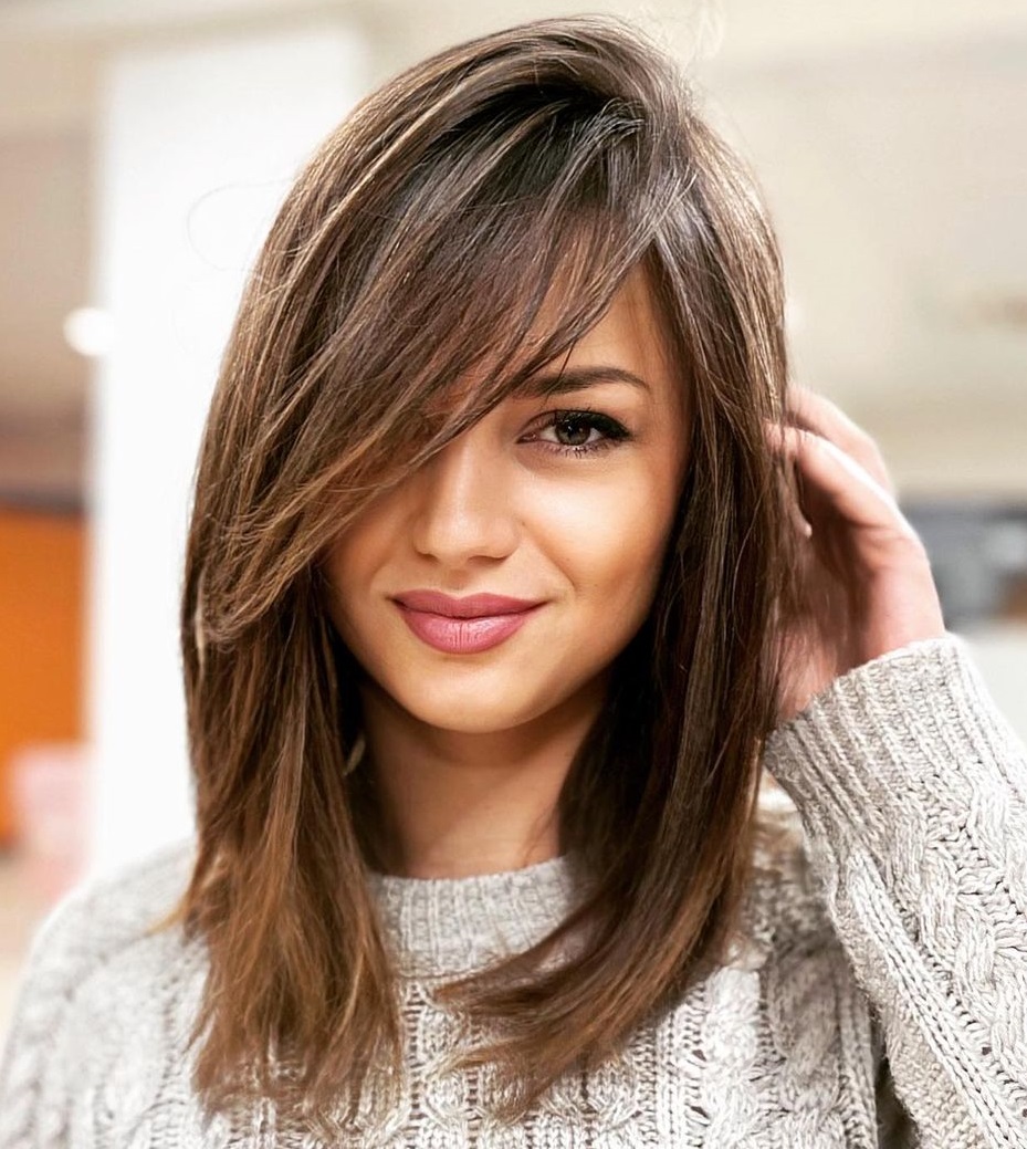 Medium-Length Brown Hair with Side-Swept Layers and Knit Sweater Medium-Length Brown Hair with Side-Swept Layers and Knit Sweater — Trendy Haircuts for Women