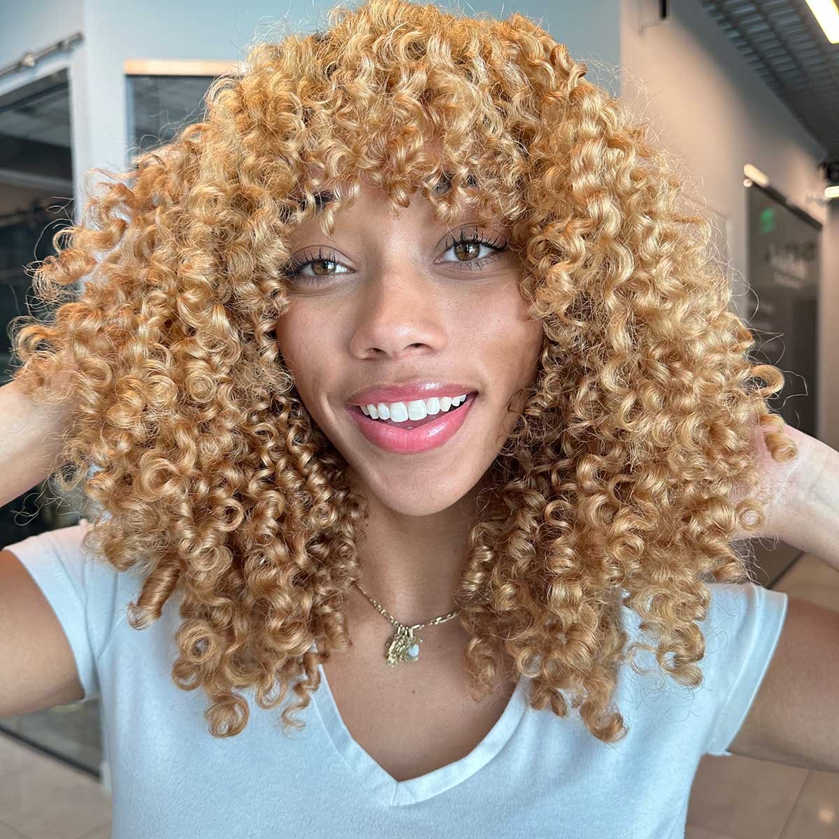 Bright Blonde Curly Hair with White T-Shirt and Gold Necklace — Blonde Hair Colour