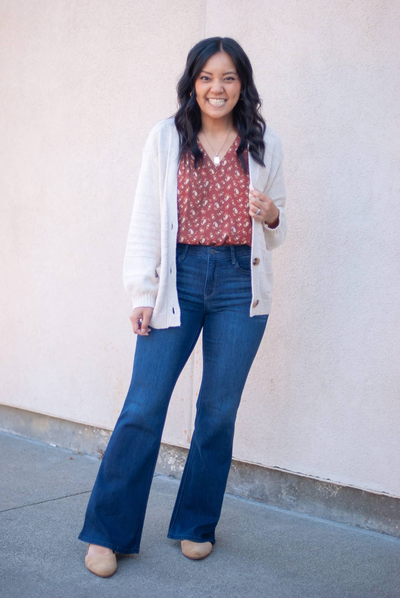 Cream Cable Knit Cardigan Over Floral Blouse and Flared Jeans — Winter to Spring Transition Outfits