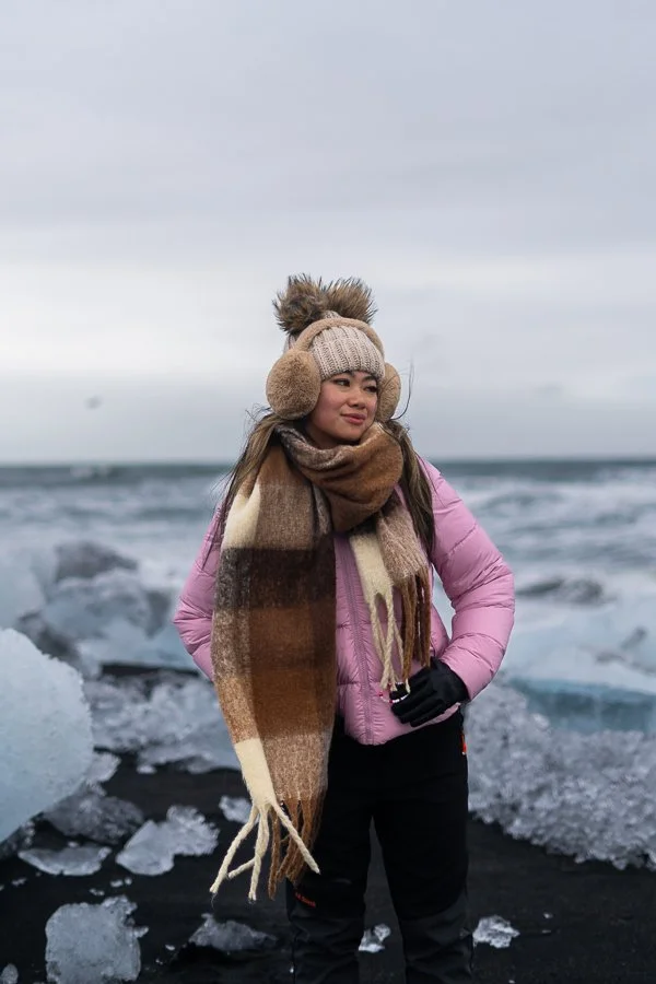 Pink Puffer Jacket with Plaid Scarf on a Black Sand Beach Pink Puffer Jacket with Plaid Scarf on a Black Sand Beach — Iceland Winter Outfits