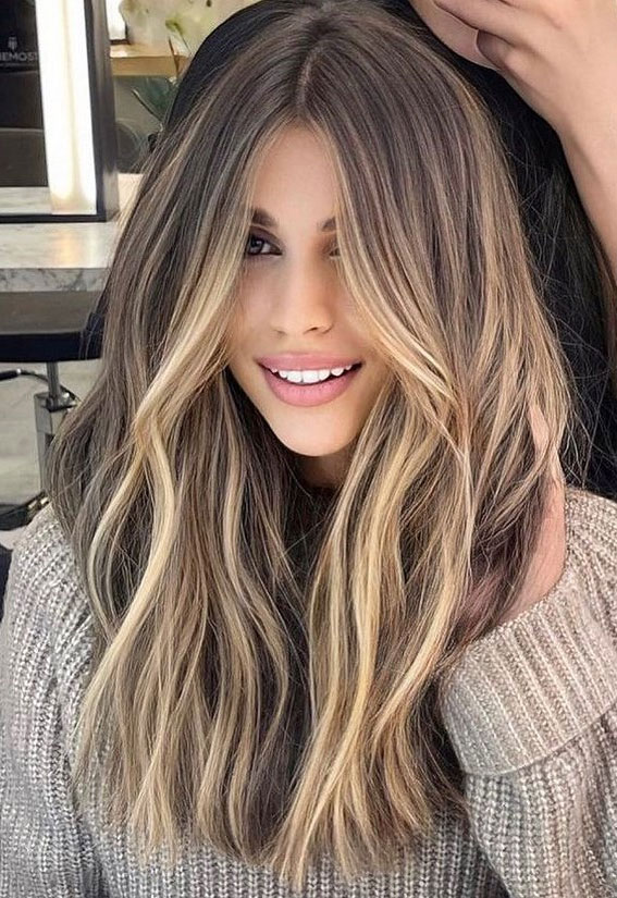 Long Wavy Hair with Honey Blonde Highlights and Grey Sweater Long Wavy Hair with Honey Blonde Highlights and Grey Sweater — Trendy Haircuts for Women