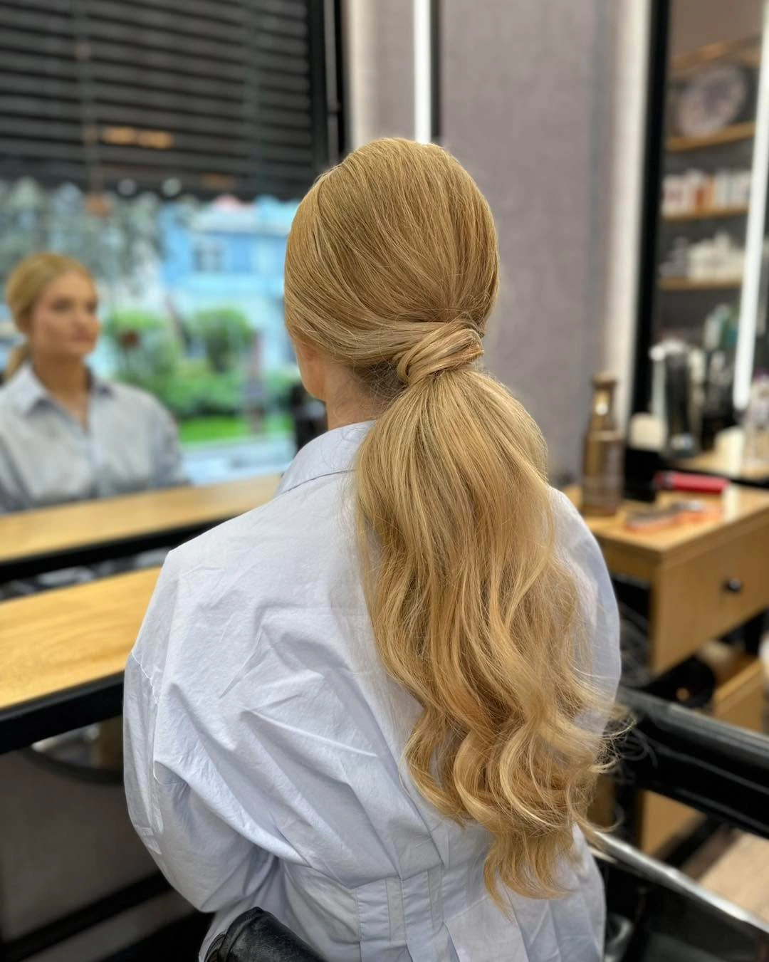 Blonde low ponytail with wrapped base and wavy length