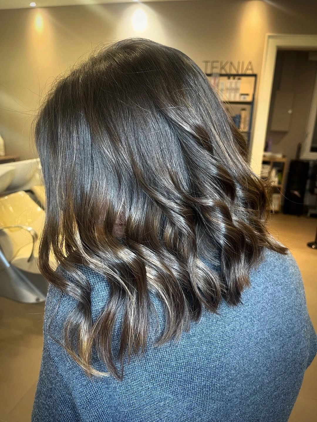 Shoulder-length dark hair with loose waves and lighter ends