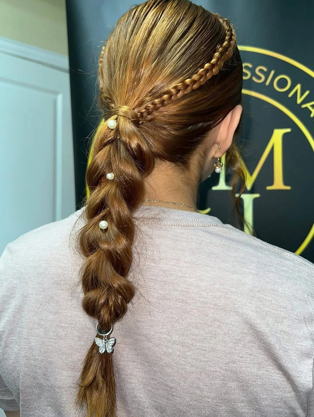 Gathered hairstyle with crown braid, pale accents, and butterfly charm
