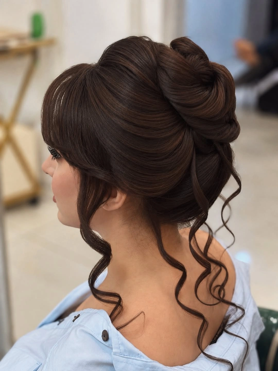 Voluminous dark updo with rounded bangs and curled tendrils
