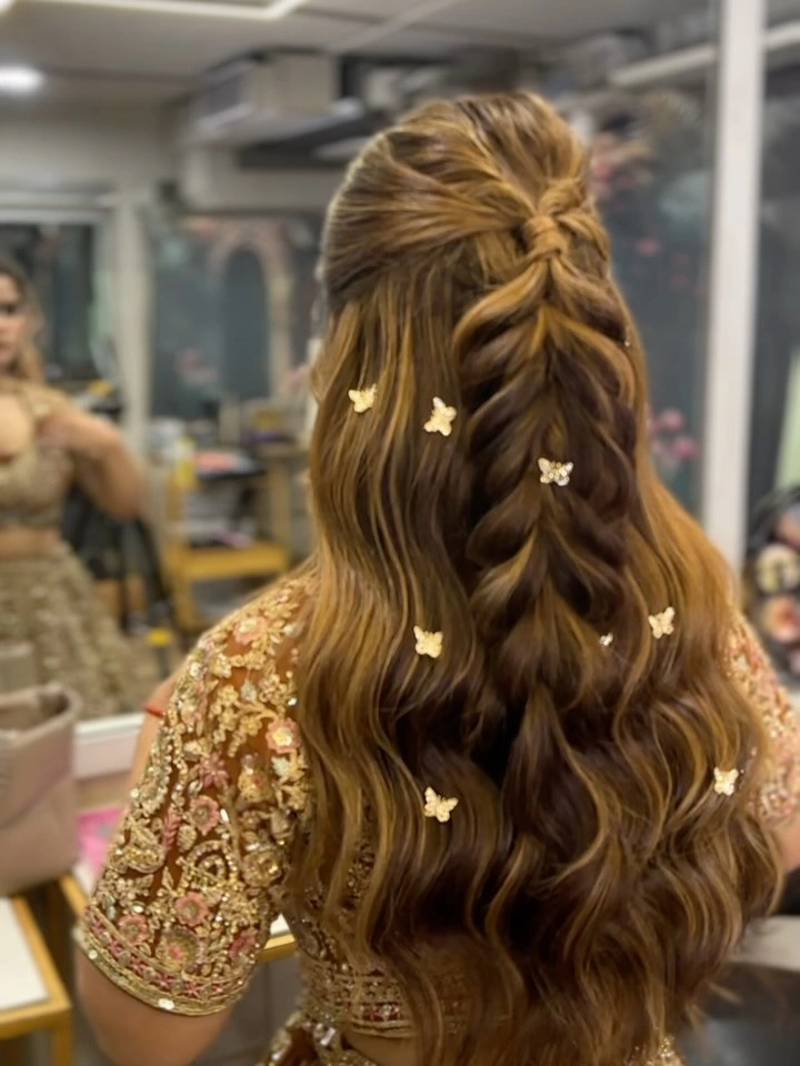 Long warm-toned hair with half-up braid and butterfly-shaped accessories