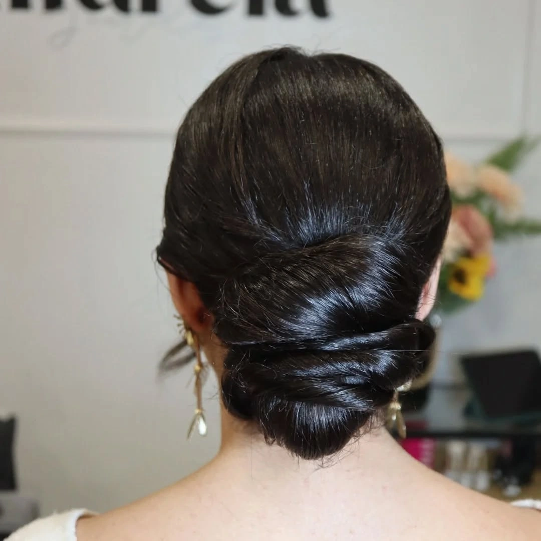 Dark glossy low bun wrapped neatly at the nape