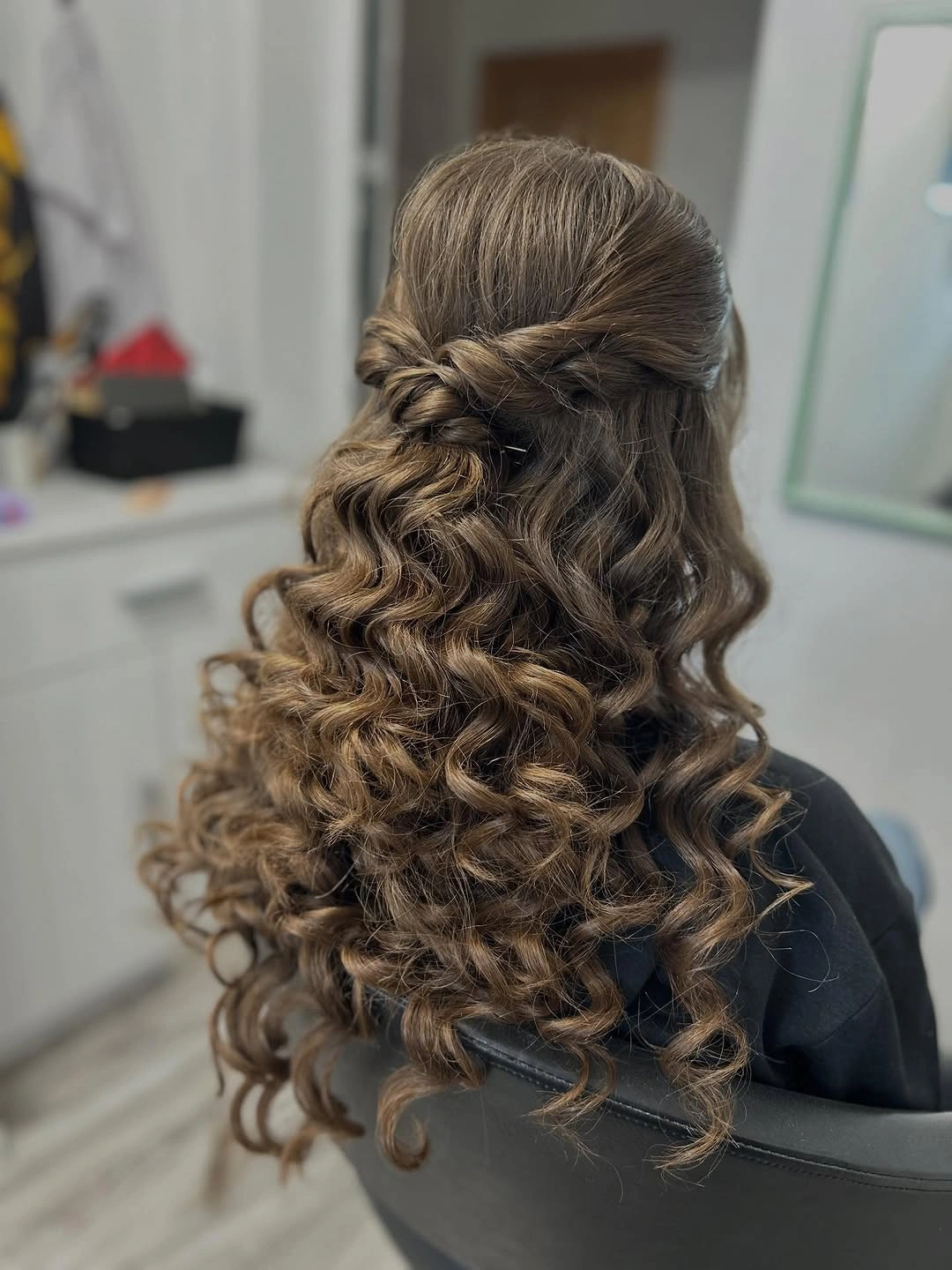 Half-up hairstyle with crown twists and defined loose curls