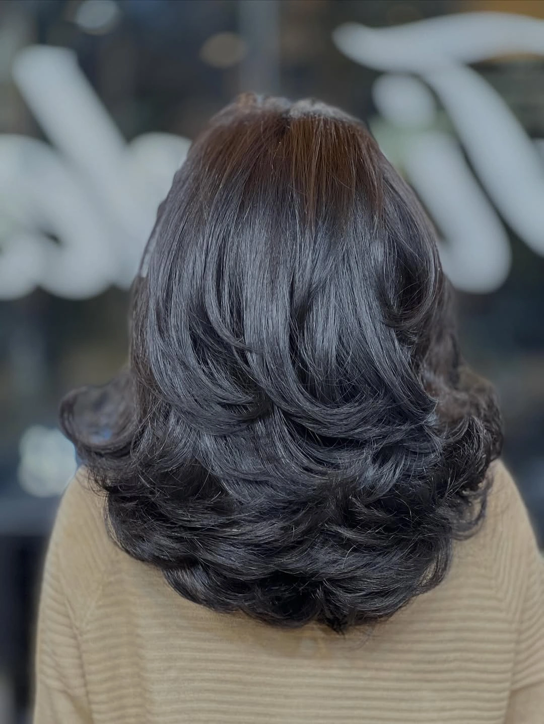 Dark medium layered hair with rounded volume and flipped ends