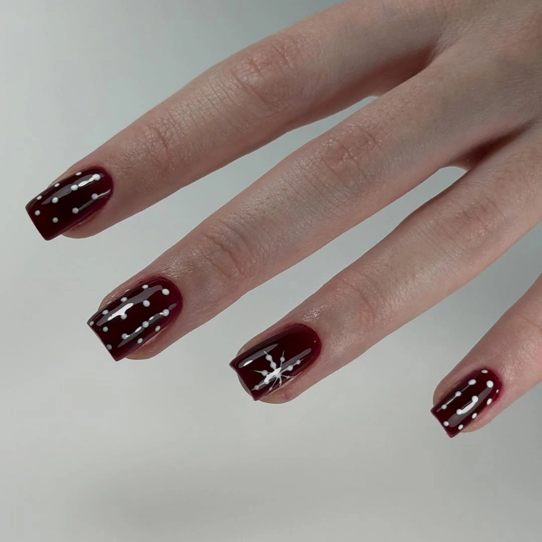 Pink and brown square nails with bows, snowflakes, and reindeer