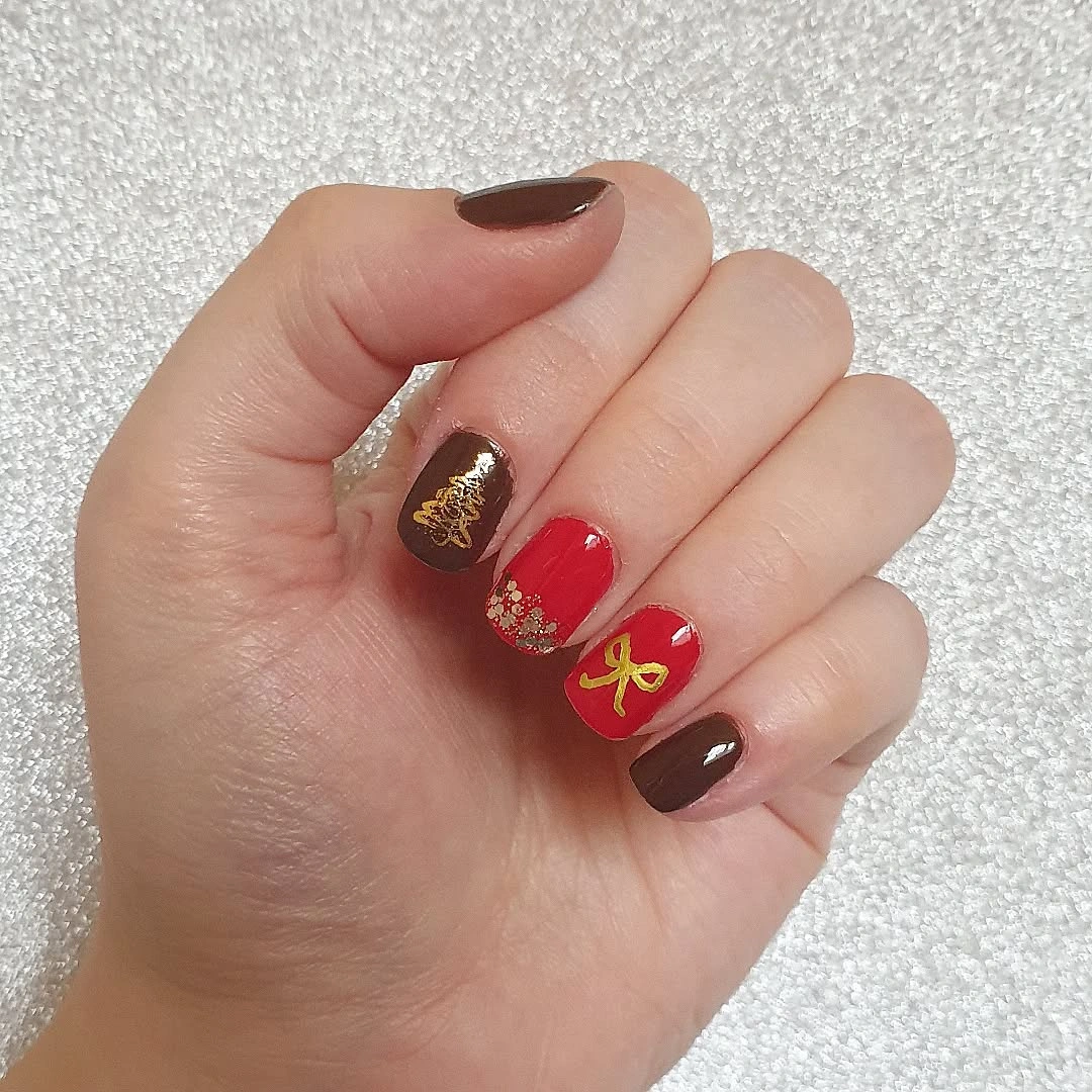 Long nude square nails with red glitter, antlers, and bow accents