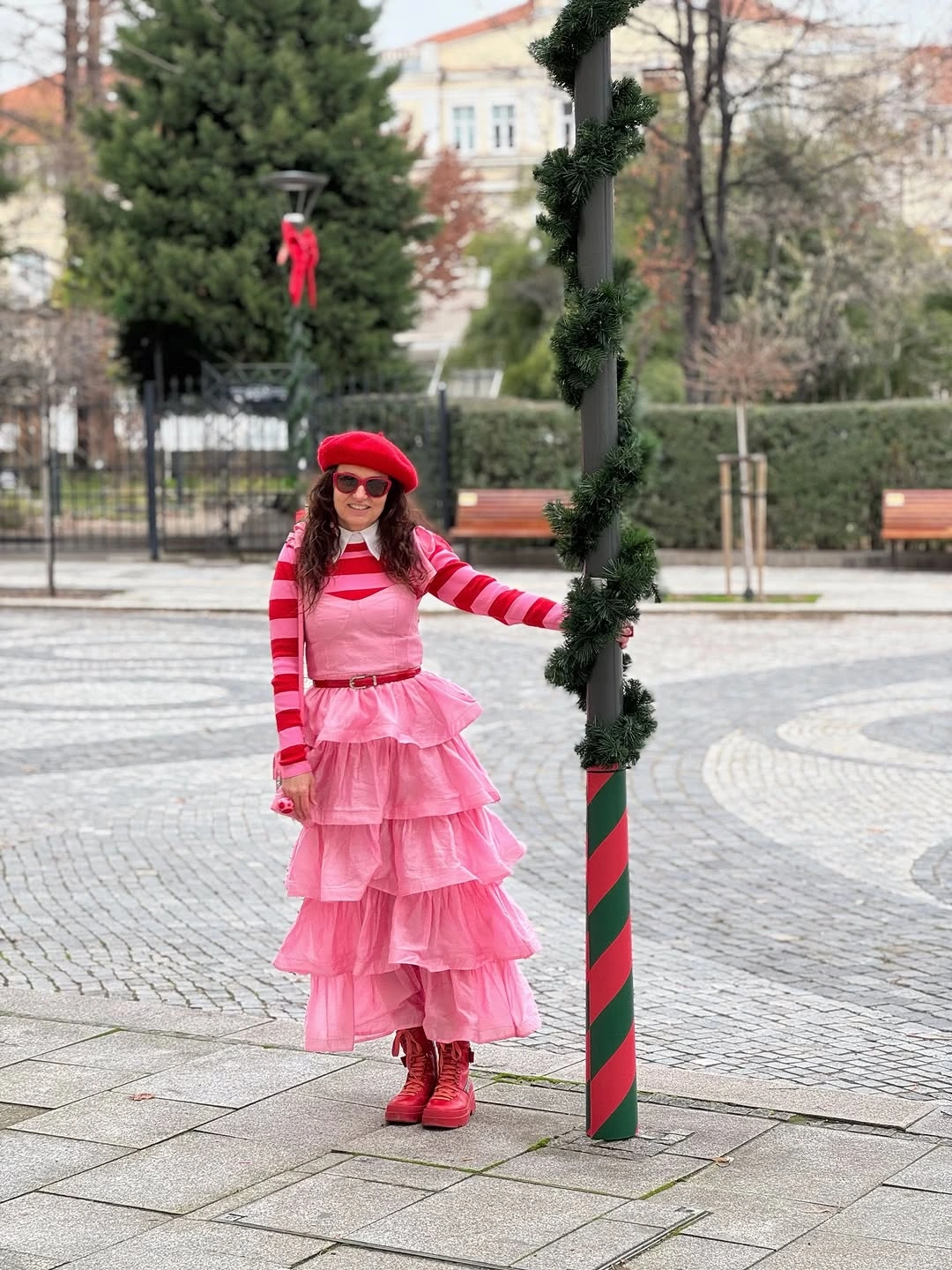 Pink tiered dress with red beret, boots and sunglasses