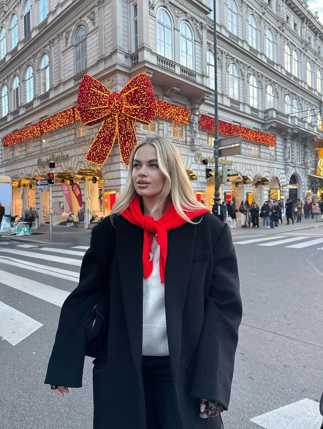 Black coat and red neck scarf under large red bow