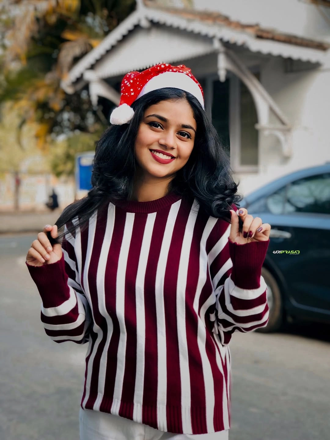 Burgundy striped sweater with red Santa hat outdoors