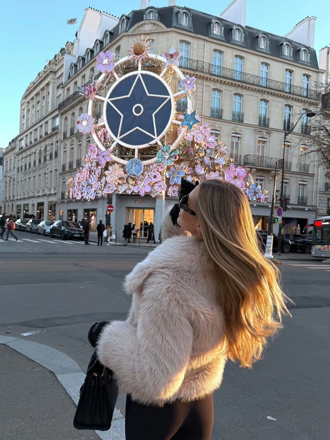 Cropped pale fuzzy jacket with black outfit on city street