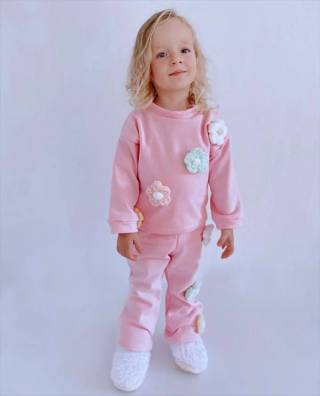 Child wearing a pink Christmas pajama set