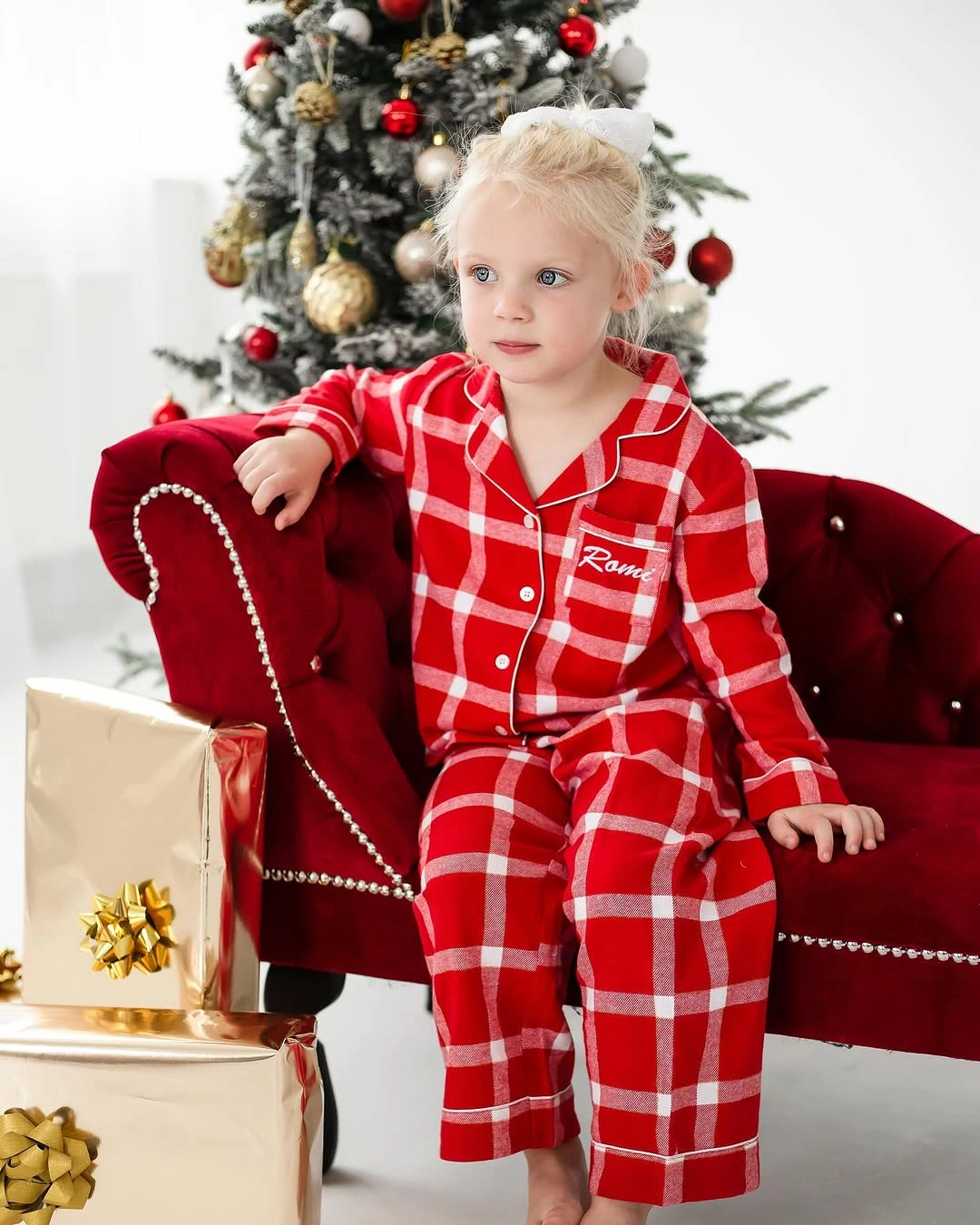 Child wearing red and white plaid button front pajamas
